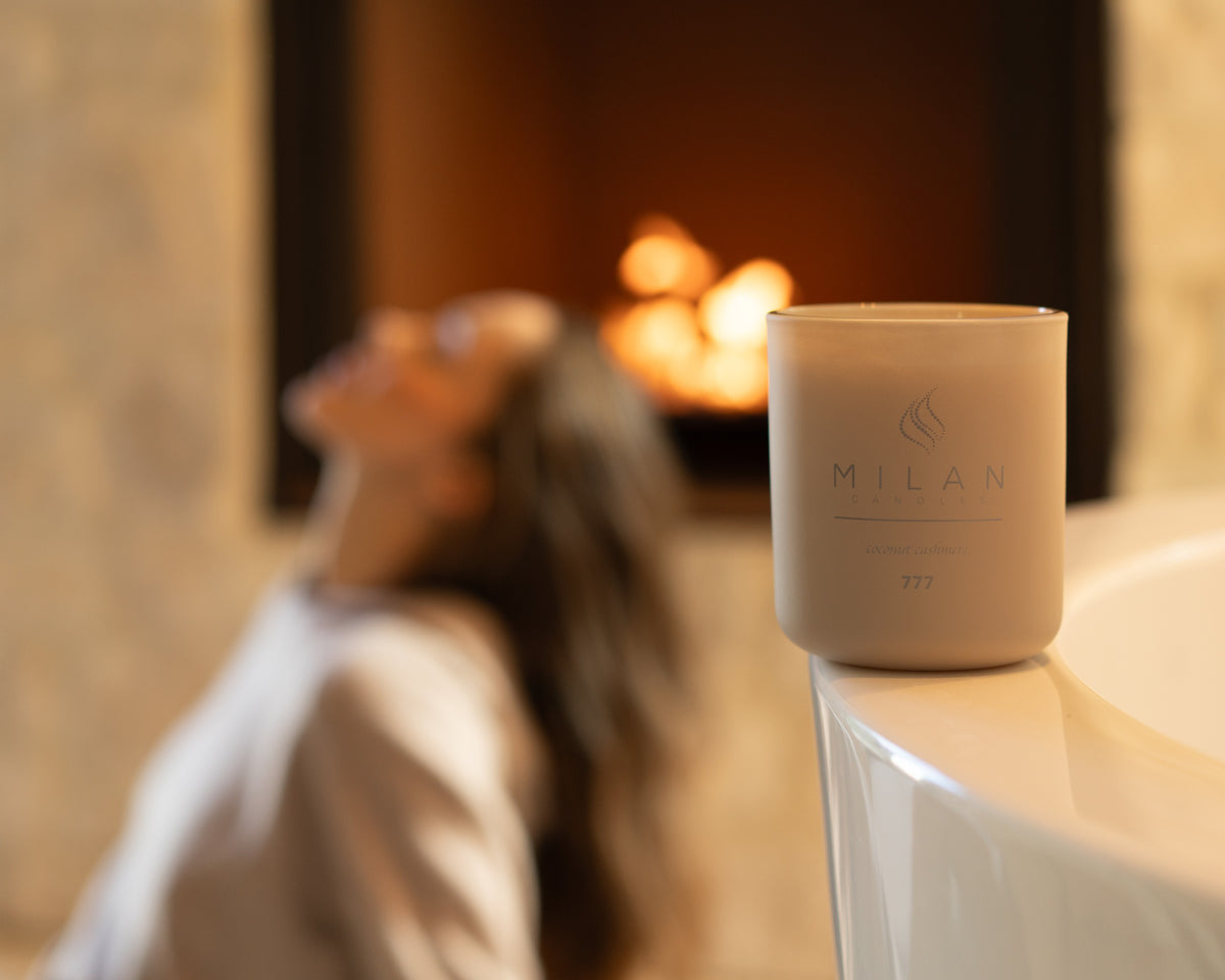 777 Coconut Cashmere on a curved bath edge, with a model and warm fireplace in the background